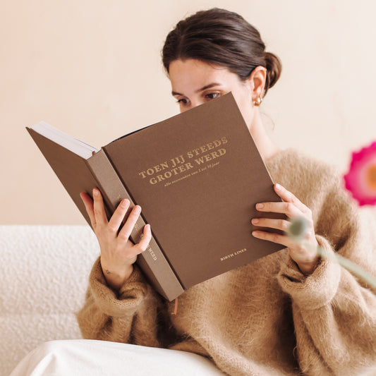 Toen jij steeds groter werd opgroei invulboek in linnen kaft met goudfolie titel vastgehouden en bekeken