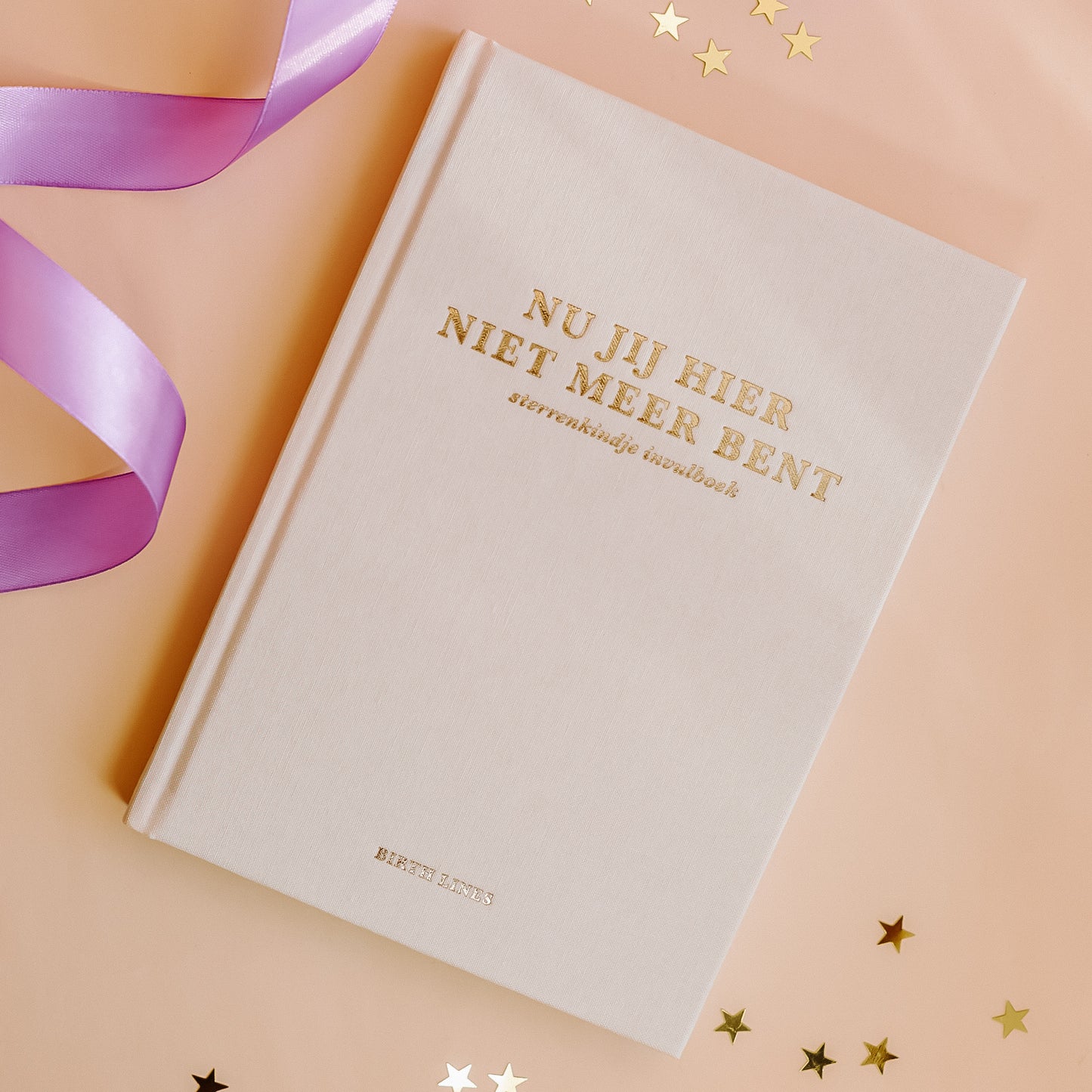 Birth Lines sterrenkindje invulboek Nu jij hier niet meer bent met linnen kaft en goudfolie titel op warme beige achtergrond met lint en sterretjes