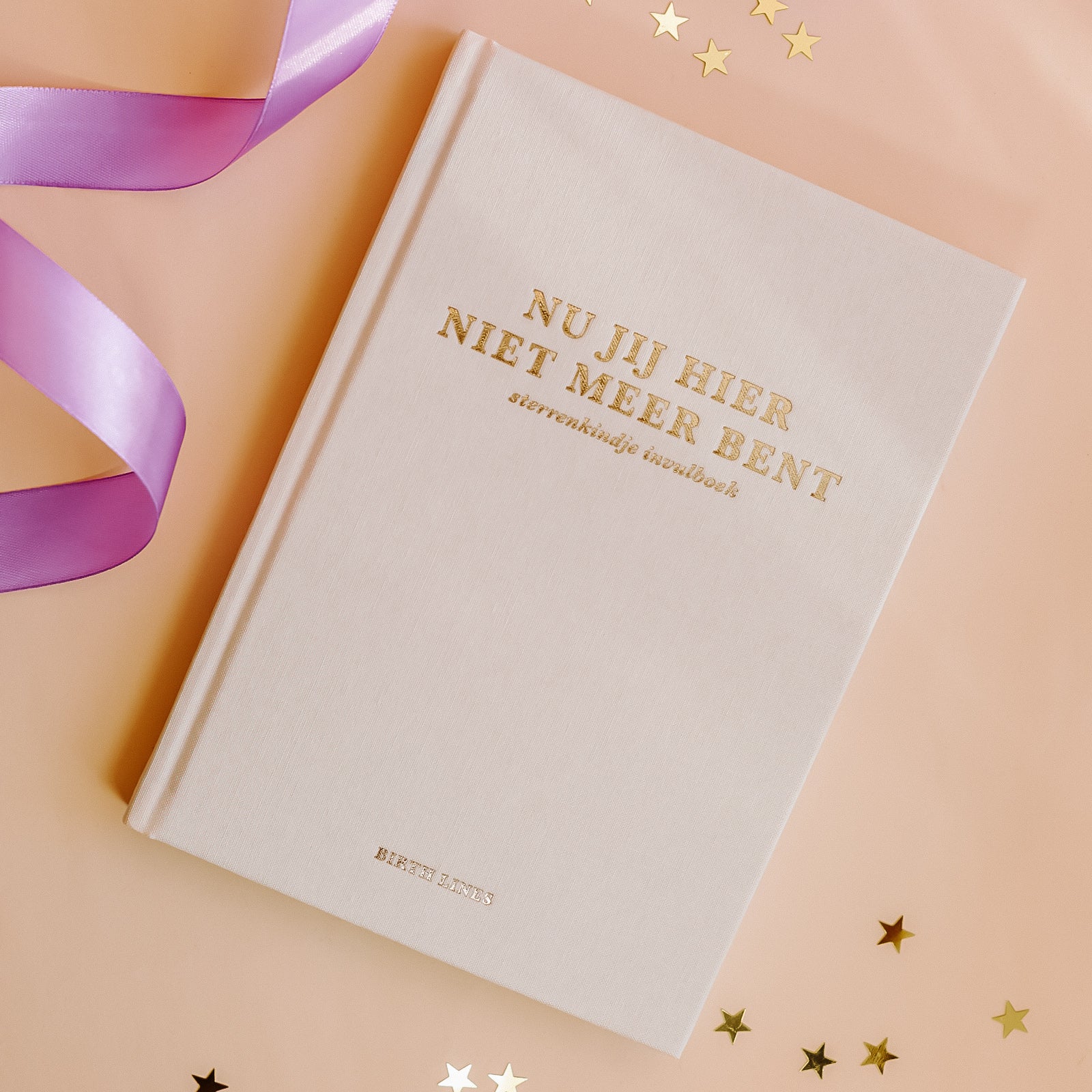 Birth Lines sterrenkindje invulboek Nu jij hier niet meer bent met linnen kaft en goudfolie titel op warme beige achtergrond met lint en sterretjes